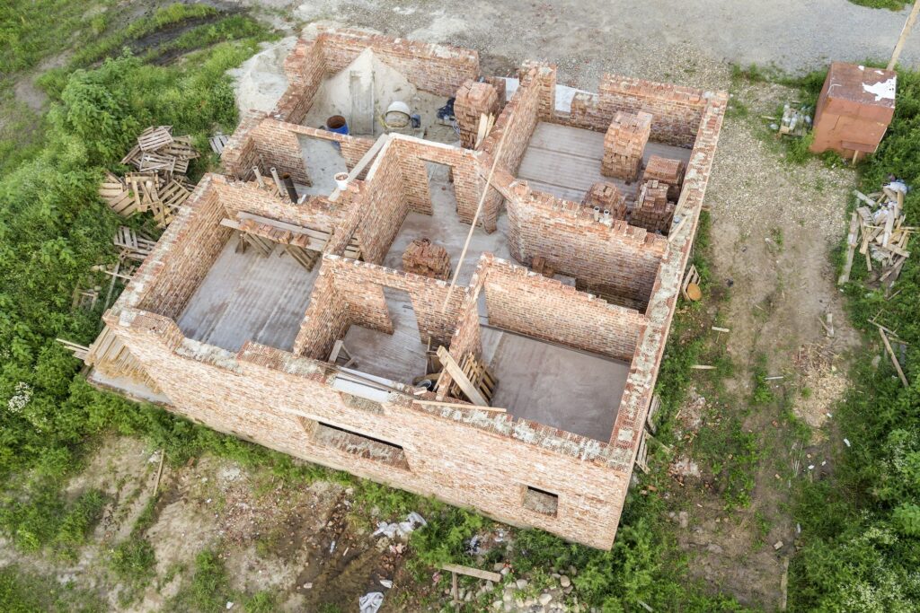 Aerial view of building site for future house, brick basement floor and stacks of brick for